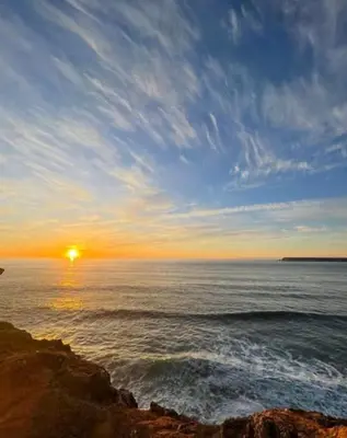 a sunset over the ocean with the sun setting at Bella Sunset Holidays - 3 min da Praia da Mareta in Sagres