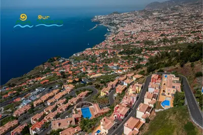 an aerial view of a city and the ocean at OurMadeira - Palheiro Eagle in Funchal