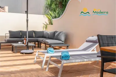 a patio with couches and tables and a sign at OurMadeira - Palheiro Eagle in Funchal