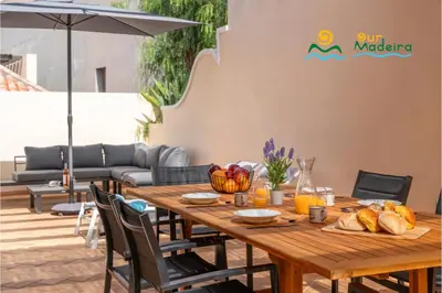 a wooden table with food on top of a patio at OurMadeira - Palheiro Eagle in Funchal