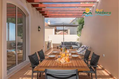 a wooden table and chairs on a patio at OurMadeira - Palheiro Eagle in Funchal
