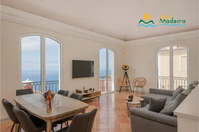 a living room with a table and chairs at OurMadeira - Palheiro Eagle in Funchal
