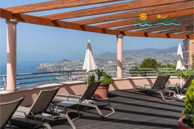 a balcony with chairs and a view of the ocean at OurMadeira - Palheiro Eagle in Funchal