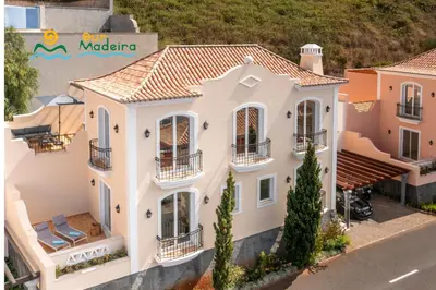 a large white house with balconies on a street at OurMadeira - Palheiro Eagle in Funchal