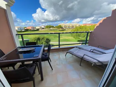 a balcony with a table and chairs and a view at Beautiful 2 bed townhouse on Boavista golf course in Lagos