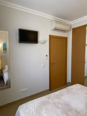 a bedroom with a bed and a television on the wall at Beautiful 2 bed townhouse on Boavista golf course in Lagos