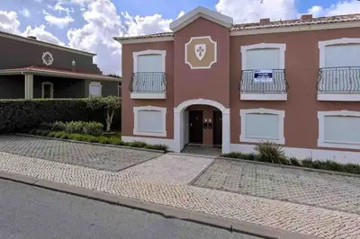 a large pink house with white shutters at Beautiful 2 bed townhouse on Boavista golf course in Lagos