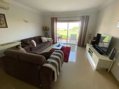 a living room with a couch and a flat screen tv at Beautiful 2 bed townhouse on Boavista golf course in Lagos