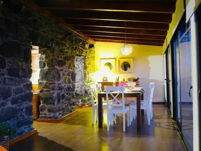 a dining room with a table and white chairs at Atlantis Country House in Calheta