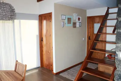 a living room with a wooden spiral staircase and a door at Atlantis Country House in Calheta