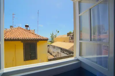 a view of a yellow building from a window at Santa Maria Hostel in Funchal