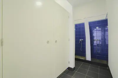 a bathroom with blue tiled walls and a mirror at Santa Maria Hostel in Funchal
