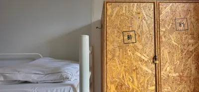a bedroom with a wooden door next to a bed at Santa Maria Hostel in Funchal