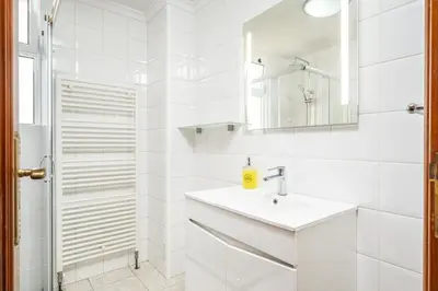a white bathroom with a sink and a mirror at Bela Vista Valley in Calheta