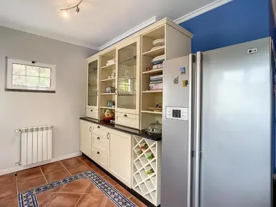 a kitchen with white cabinets and a refrigerator at Vinhaticos Villa by Atlantic Holiday in Porto Moniz