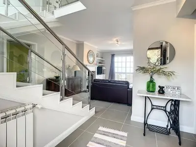 a living room with a staircase and a couch at Vinhaticos Villa by Atlantic Holiday in Porto Moniz