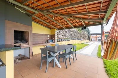 a patio with a table and chairs under a pergola at Shell House by GALMI in Arco da Calheta