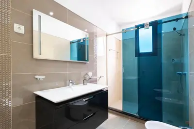 a bathroom with a sink and a glass shower at Shell House by GALMI in Arco da Calheta