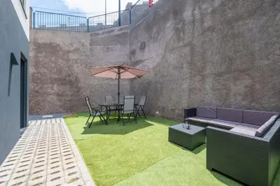 a patio with a couch and a table with an umbrella at Villa Bela Horizonte by GALMI in Caniço
