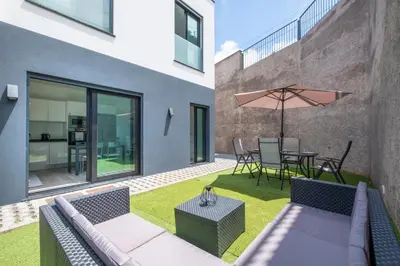 a patio with a couch and a table with an umbrella at Villa Bela Horizonte by GALMI in Caniço