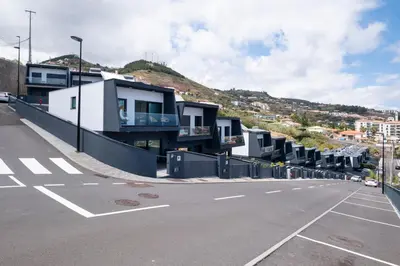 an empty parking lot with houses on a hill at Villa Bela Horizonte by GALMI in Caniço
