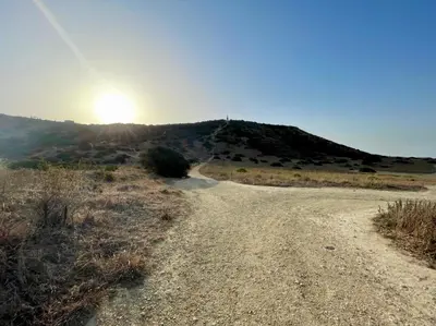 a dirt road with the sun on a hill at E&M Apartment Luz in Luz