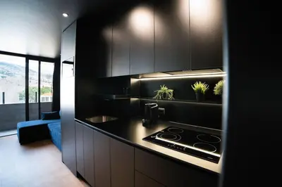 a kitchen with black cabinets and a stove top oven at SUPER Central - Deep Blue in Funchal