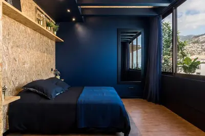 a blue bedroom with a bed and a window at SUPER Central - Deep Blue in Funchal