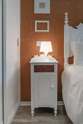 a white table with a lamp on it next to a bed at SUPER Central - Cork in Funchal
