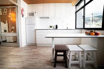 a kitchen with white cabinets and a table and chairs at SUPER Central - Cork in Funchal
