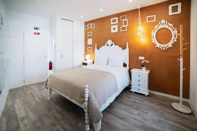 a bedroom with a white bed and a orange wall at SUPER Central - Cork in Funchal