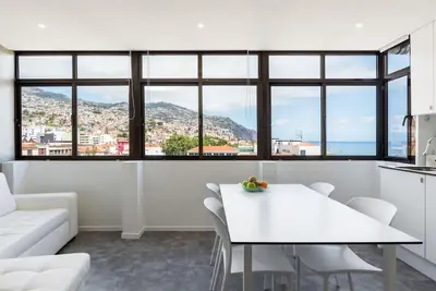 a kitchen and living room with a white table and chairs at SUPER Central - Silver in Funchal