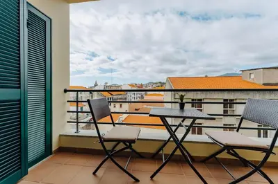 a balcony with a table and chairs on a balcony at SUPER Anadia - Golden in Funchal