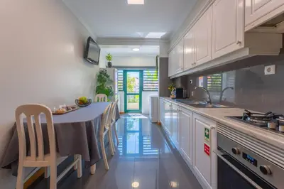 a kitchen with a table with chairs and a sink at SUPER Anadia - Olive in Funchal