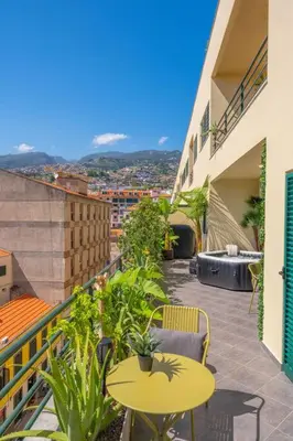 a balcony with tables and chairs and a view of a city at SUPER Anadia - Olive in Funchal