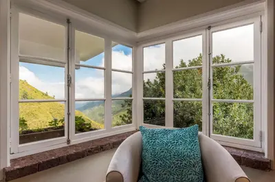 a room with a couch in front of windows at Rabaçal Nature Spot Cottage in Estreito da Calheta