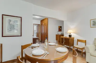a dining room and living room with a table and chairs at Refugio Madeirense by Atlantic Holiday in Funchal