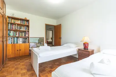 a bedroom with two beds and a book shelf at Refugio Madeirense by Atlantic Holiday in Funchal