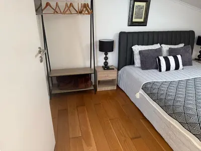 a bedroom with a bed and a wooden floor at Apartamento Deluxe II RB in Ribeira Brava