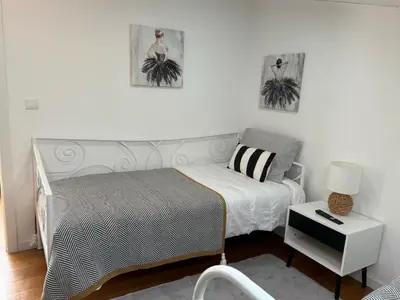 a small bedroom with a bed and a chair at Apartamento Deluxe II RB in Ribeira Brava