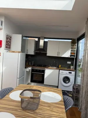 a kitchen with a wooden table and white appliances at Apartamento Deluxe II RB in Ribeira Brava