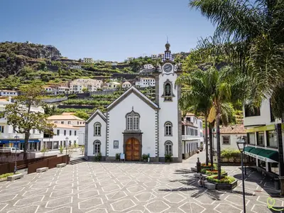 a large white building with a clock tower on a hill at Apartamento Deluxe II RB in Ribeira Brava