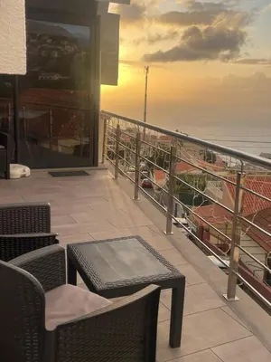 a balcony with chairs and a table and the ocean at Apartamento Deluxe II RB in Ribeira Brava