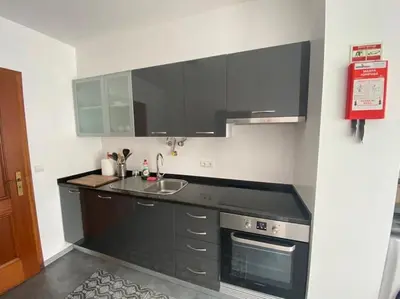 a kitchen with a black counter top and a sink at Residência Azevedo in Câmara de Lobos