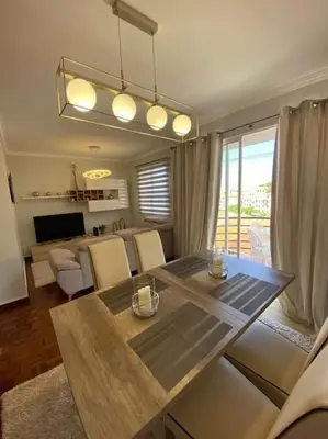 a living room with a dining table and a living room with at Residência Azevedo in Câmara de Lobos