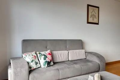 a gray couch with two pillows in a living room at Tamariz Sea View, a Home in Madeira in Caniço