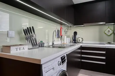 a kitchen with a sink and a washing machine at Tamariz Sea View, a Home in Madeira in Caniço