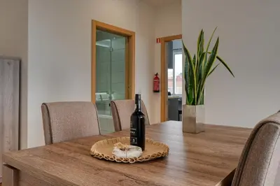 a bottle of wine sitting on top of a wooden table at Tamariz Sea View, a Home in Madeira in Caniço