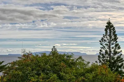 two trees in front of a body of water at Tamariz Sea View, a Home in Madeira in Caniço