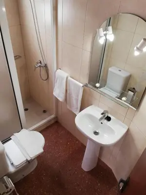 a bathroom with a sink and a toilet and a mirror at FXapartment1 in Funchal